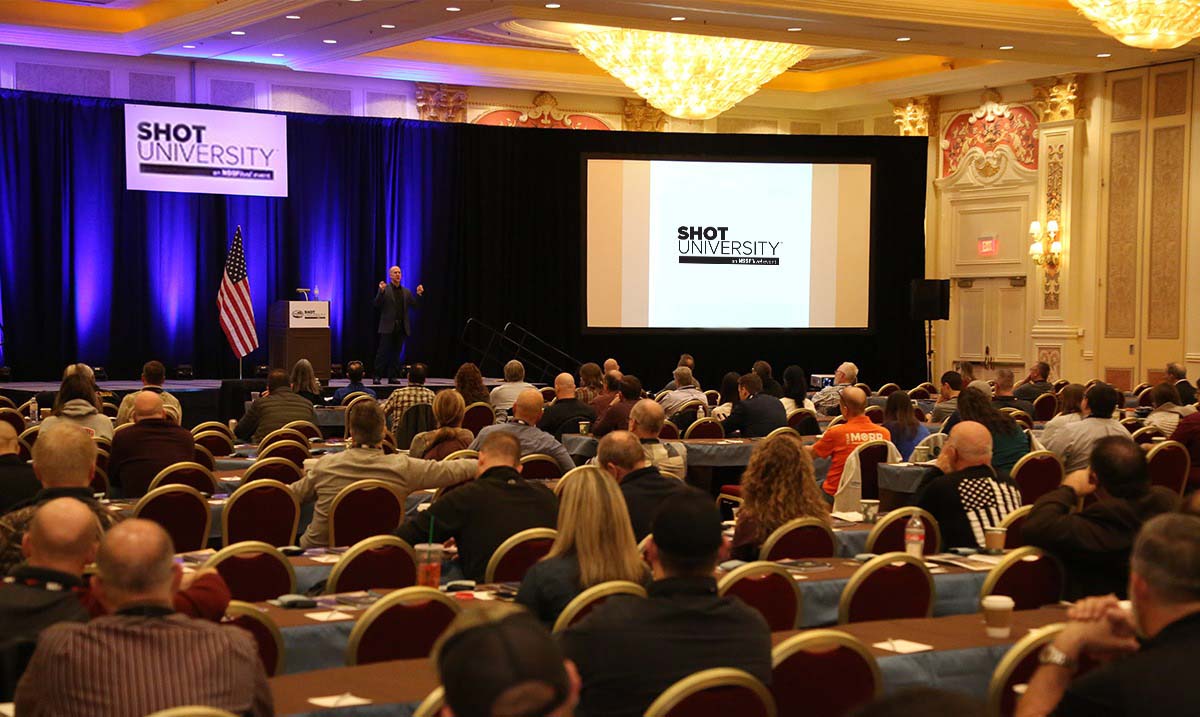 A general photo of SHOT University Live education stage from behind a seated crowd at NSSF's annual SHOT Show in Las Vegas